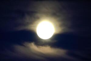 lune dans le nuit ciel. près le lune une petit montant de des nuages photo