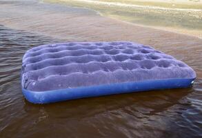 bleu gonflable matelas nager dans le étang photo