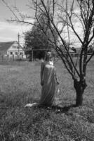 noir et blanc photo, fille dans le jardin sur une Prairie dans une robe. photo