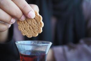 verser sucré biscuits dans une thé tasse photo