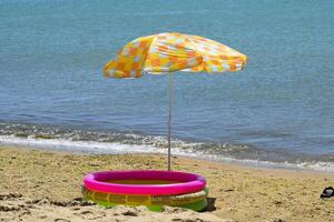 plage parapluie de le Soleil sur le plage. noir mer. photo