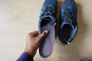 Hommes main en mettant orthopédique semelles dans des chaussures photo