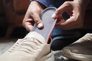 Hommes main en mettant orthopédique semelles dans des chaussures photo