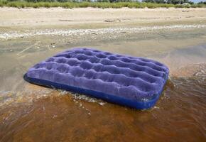 bleu gonflable matelas nager dans le étang photo