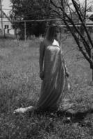 noir et blanc photo, fille dans le jardin sur une Prairie dans une robe. photo