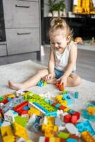 caucasien enfant une peu fille est en jouant dans le constructeur à maison. éducatif jouets pour les enfants. photo