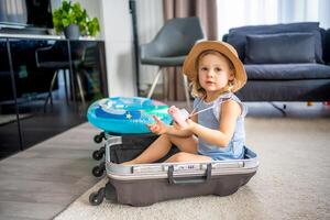 peu fille dans valise bagages bagage prêt à aller pour en voyageant sur vacances photo