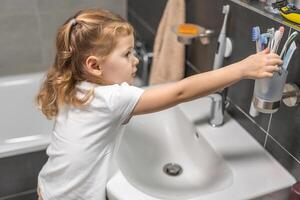 content bambin fille brossage les dents dans le une baignoire photo