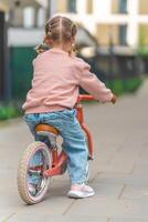 peu fille équitation équilibre bicyclette dans le Cour de le résidence dans Prague, L'Europe  photo