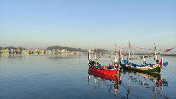 coloré pêche bateaux ancré dans le port sur paiton plage Indonésie photo