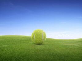 tennis Balle sur vert Prairie sur petit colline et bleu ciel avec des nuages photo