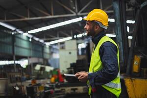 ingénieur Regardez projets et Planification avec tablette mobile dans usine photo