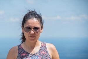 portrait de une hispanique femme portant des lunettes avec une doux lumière bleu ciel Contexte. photo