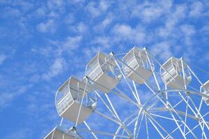 blanc ferris roue contre le bleu ciel. ferris roue dans le parc photo