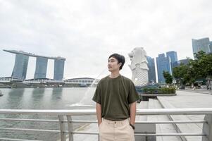 homme dans merlion Fontaine dans de face de le Marina baie photo