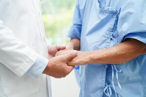 médecin tenant par la main une patiente âgée asiatique, aide et soins à l'hôpital. photo