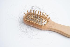 une femme asiatique a un problème avec la perte de cheveux longs attachée à la brosse à peigne. photo