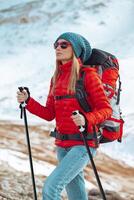 actif femme avec en marchant poteaux dans le montagnes photo