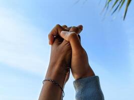couple en portant mains comme une signe de affection avec le ciel dans le Contexte photo