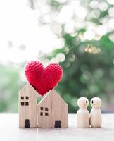 en bois figure couple content visage et miniature maison avec cœur. le concept de romantique sentiments, famille relation. photo