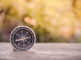 proche en haut boussole sur table dans le le coucher du soleil temps. le concept de monde tourisme jour, recherche le droite directions et Voyage photo