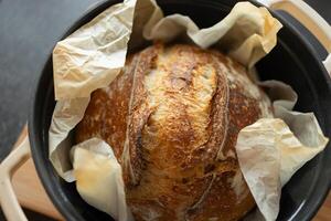 Frais fait maison levain pain dans jeter le fer la poêle sur en bois Coupe conseil, fermer photo