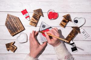 femelle mains dessiner une cœur sur une en bois maison, étape par étape bricolage, artisanat sucré Accueil photo
