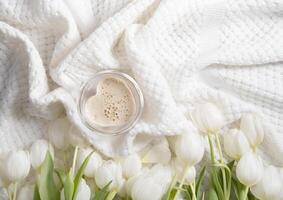 flatley tasse avec en forme de coeur café sur une Contexte avec blanc tulipes, printemps photo