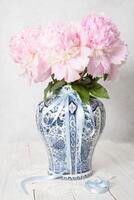 rose luxueux pivoines dans un ancien chinois vase avec bleu ornement, printemps photo