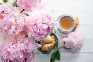 délicat printemps encore la vie avec des croissants et une bouquet de rose pivoines photo