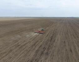 semis de maïs. tracteur avec une semoir sur le champ. en utilisant une semoir pour plantation maïs. photo