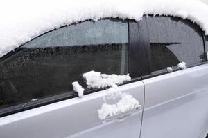 tomber endormi humide neige auto. chute de neige de humide neige. neige mensonge sur le voiture photo