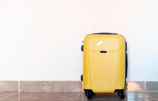 Jaune valise sur blanc mur Contexte dans Hôtel pièce photo