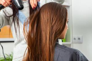 photo de une européen fille avec longue et magnifique brunette cheveux à le beauté salon. brillant et en bonne santé cheveux.