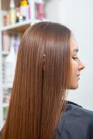 photo de une européen fille avec longue et magnifique brunette cheveux à le beauté salon. brillant et en bonne santé cheveux.