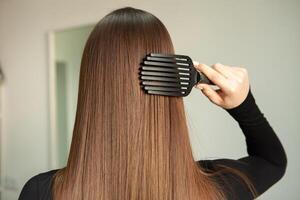 photo de une européen fille avec longue et magnifique brunette cheveux à le beauté salon. brillant et en bonne santé cheveux.