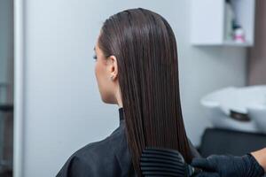 portrait de une magnifique femme avec longue marron tout droit cheveux dans une beauté salon. photo