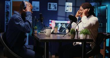 africain américain homme et femme en arrivant ensemble dans appartement studio, prêt à début enregistrement podcast. hôte attrayant client dans vivant pièce utilisé comme diffusion espace à partager histoires photo