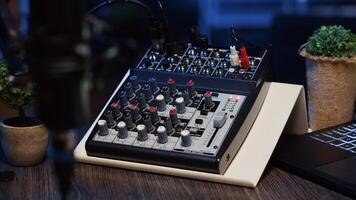 panoramique coup de professionnel analogique mixer et microphone utilisé à produire haute fidélité l'audio pendant Podcast enregistrement session dans studio. haute technologie enregistrement dispositifs sur table dans appartement photo