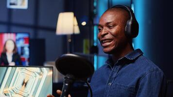 africain américain homme invité à podcast, participant dans divertissant discussion avec hôte dans appartement studio. de bonne humeur client parlant dans professionnel microphone pendant en ligne comédie spectacle photo