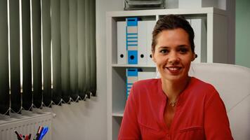 portrait de Dame souriant dans de face de caméra dans moderne Bureau chambre. lent mouvement de hispanique pigiste travail dans professionnel lieu de travail dans personnel entreprise entreprise à la recherche à webcam photo