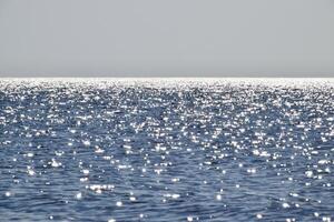 mer ligne de le horizon. mer et ciel. le vagues et éblouissement de le Soleil sont réfléchi de le vagues de le mer. paysage marin. photo