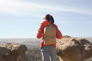 actif Jeune femme avec sac à dos randonnée dans le montagnes profiter panoramique vues. photo