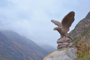 Aigle statue dans le Caucase montagnes, stavropol région, Russie. monument sur Haut de une Montagne contre le ciel sur une brumeux l'automne journée. photo