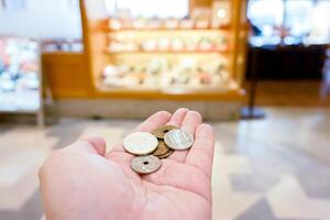 fermer Japon yen pièces de monnaie sur main de face de floue Japonais restaurant afficher, photo