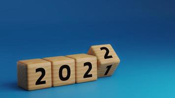 Début de l'année 2022. bloc de cube en bois renversant pour changer l'année 2021 à l'année 2022 sur fond bleu avec espace de copie. concept de bonne année. illustration de rendu 3D.