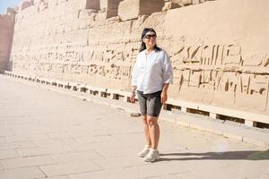 femme voyageur explore le ruines de le ancien Karnak temple dans le ville de louxor dans Egypte. photo