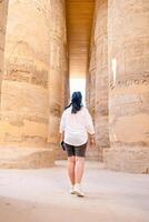 femme voyageur explore le ruines de le ancien Karnak temple dans le ville de louxor dans Egypte. photo