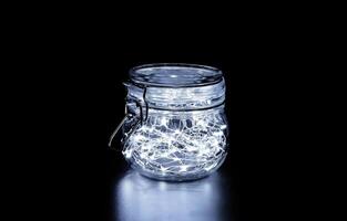 blanc Fée lumière dans une verre pot, dans le sombre, discret la photographie photo
