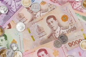 pile de thaïlandais baht billets de banque et pièces de monnaie. affaires et la finance concept. photo